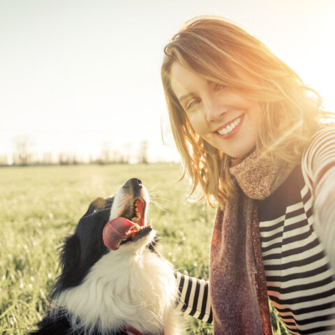 Smiling lady taking selfie with her dog